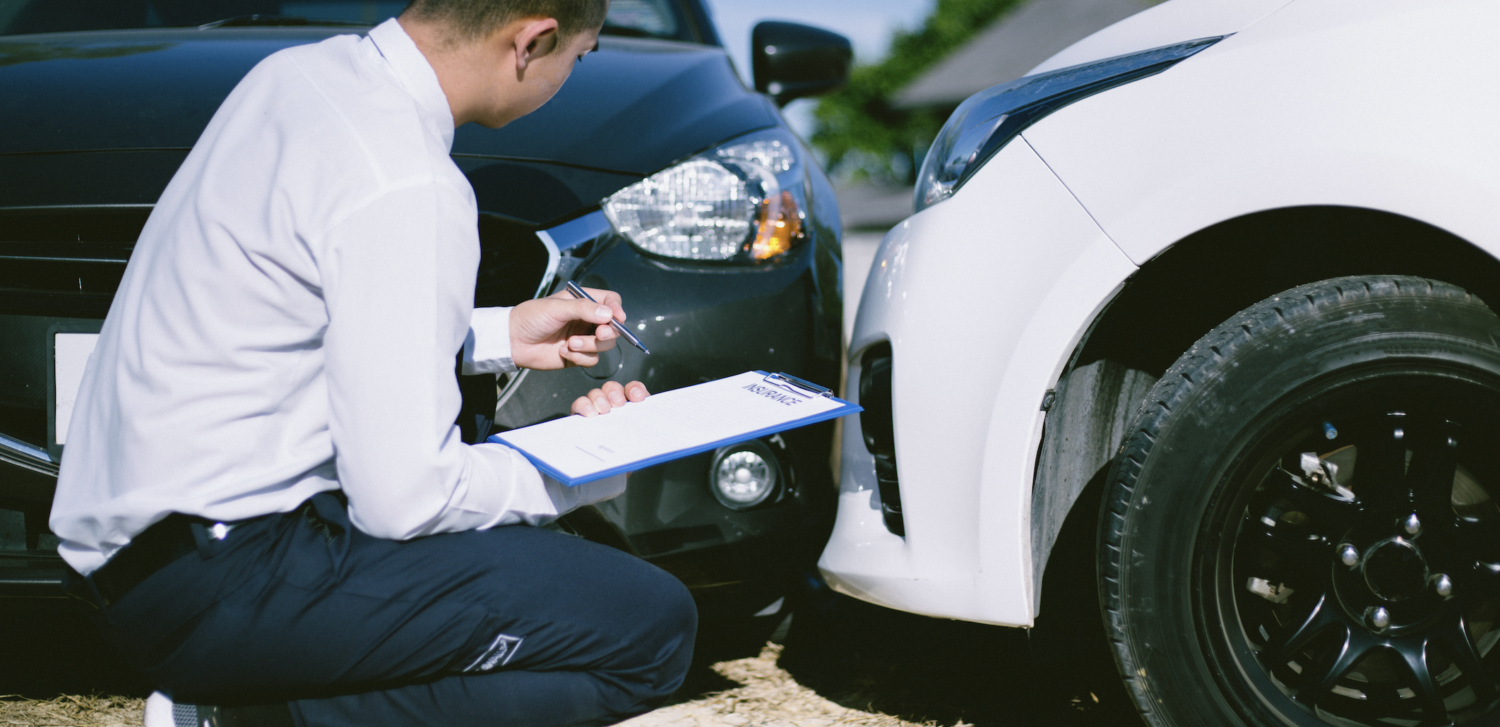 claims adjuster looking at car